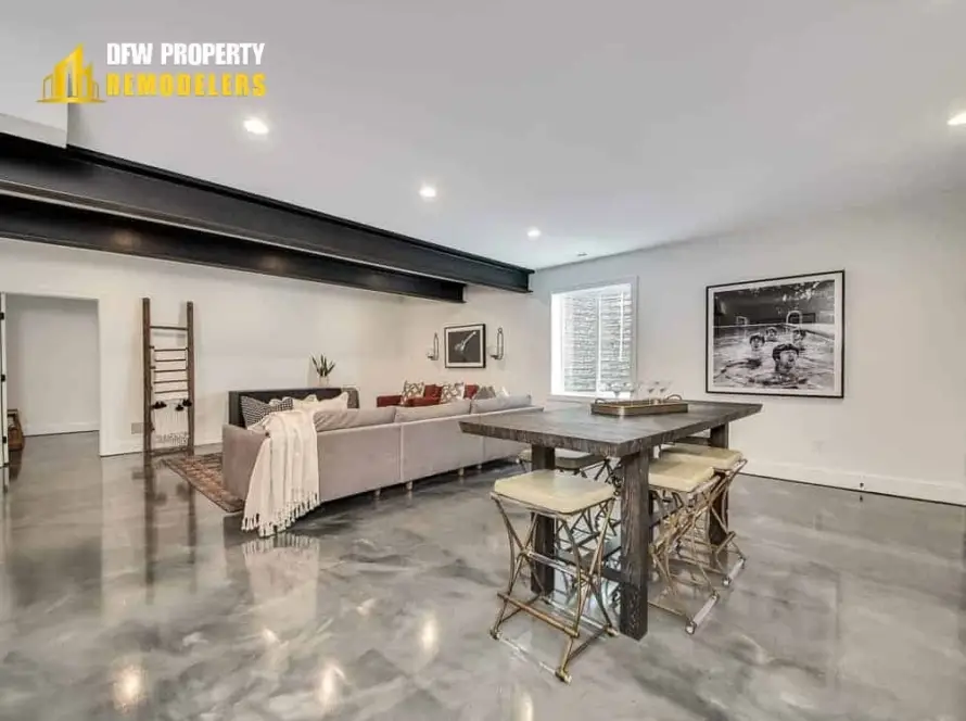 The image features a modern living room with a sectional sofa, dining table, and polished concrete floors.