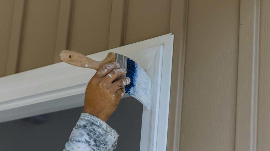 Interior House Painting of white trim with a professional paintbrush.