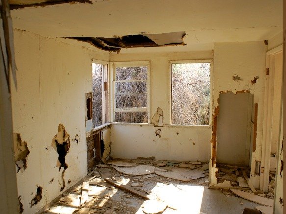 Damaged interior with cracked walls, broken ceiling, and debris showing clear need for home remodeling signs your home needs remodeling signs your home needs remodeling signs your home needs remodeling