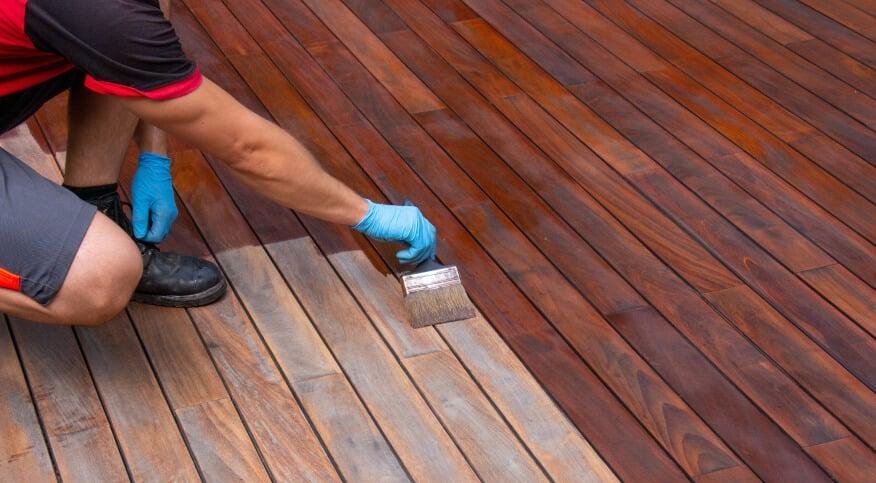 Professional Fence and Deck Staining and sanding on a wooden outdoor surface.